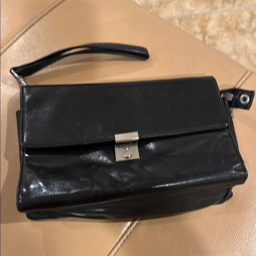 Black Messenger Bag with Sleek Design and Metallic Hardware